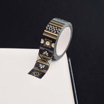 Roll of black washi tape with white flowers and leaves and gold foil