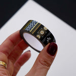 Roll of black washi tape with white flowers and leaves and gold foil