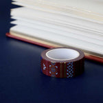Roll of red washi tape with dark blue flowers, light blue leaves and gold foil