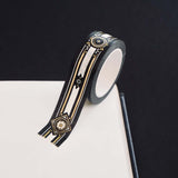 Black washi tape with white, grey and gold flowers, a white band and gold foil filagree