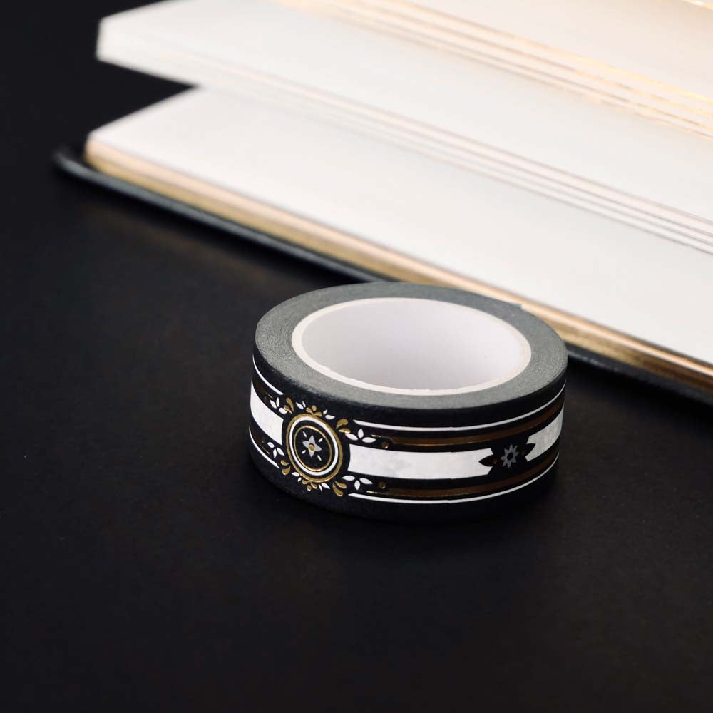 Black washi tape with white, grey and gold flowers, a white band and gold foil filagree