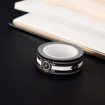 Black washi tape with white, grey and gold  flowers, a white band and gold foil filagree