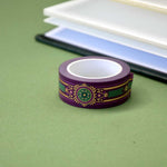 Purple washi tape with pink, gold and green flowers, a green band and gold foil filagree
