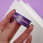 Purple washi tape with pink and gold  flowers, a pink band and gold foil filagree