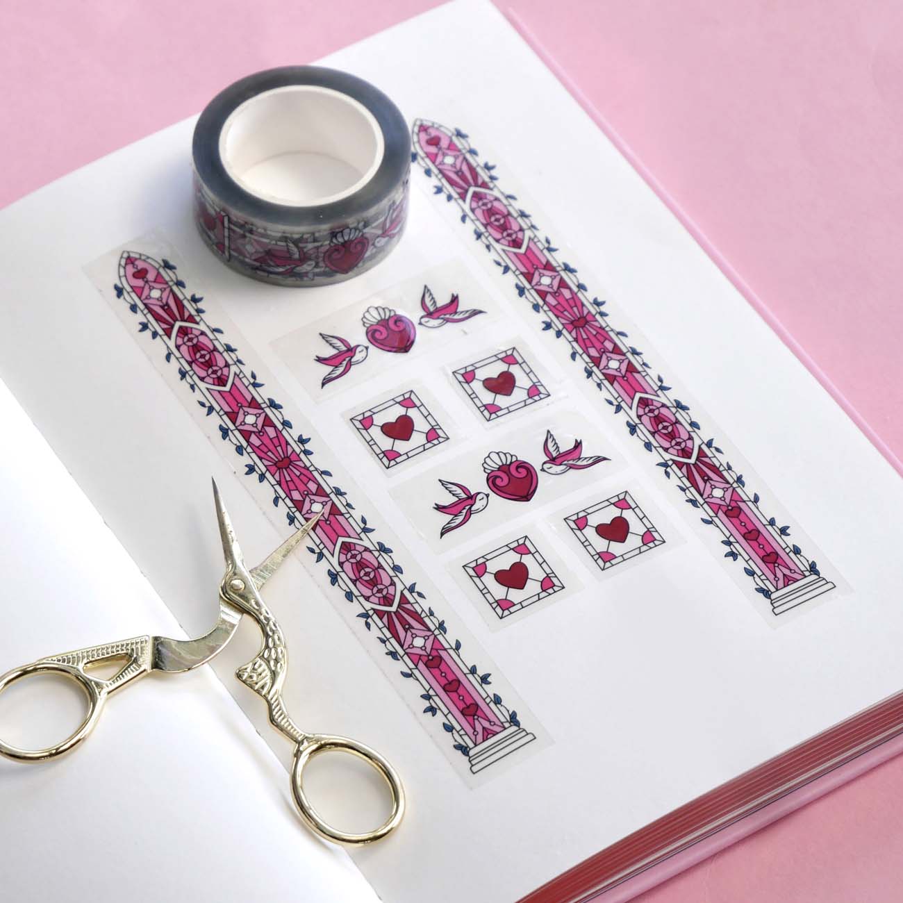 Clear washi tape with a pink panels, hearts and birds, and green foliage