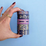 Five rolls of washi tape with blue and purple backgrounds with pink and blue flowers and gold foil