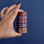 Five rolls of washi tape with red and blue backgrounds with flowers and gold foil