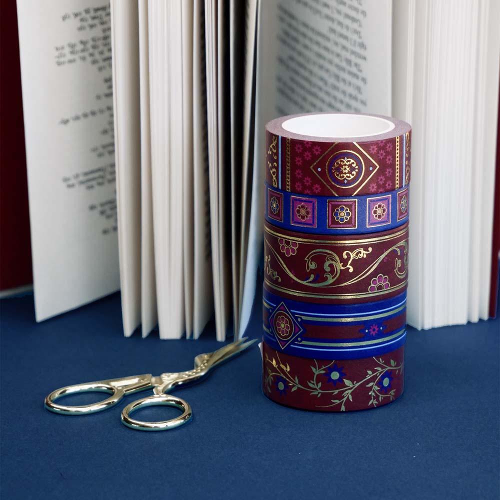 Five rolls of washi tape with red and blue backgrounds with flowers and gold foil