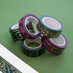 Five rolls of washi tape with green and purple backgrounds and gold foil