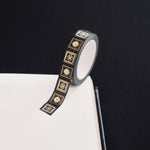 Black washi tape with white and grey flowers in squares outlined in gold foil