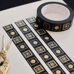 Black washi tape with white and grey flowers in squares outlined in gold foil