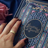 Blue faux leather reading journal with pink flowers, light blue leaves and gold foil filagree