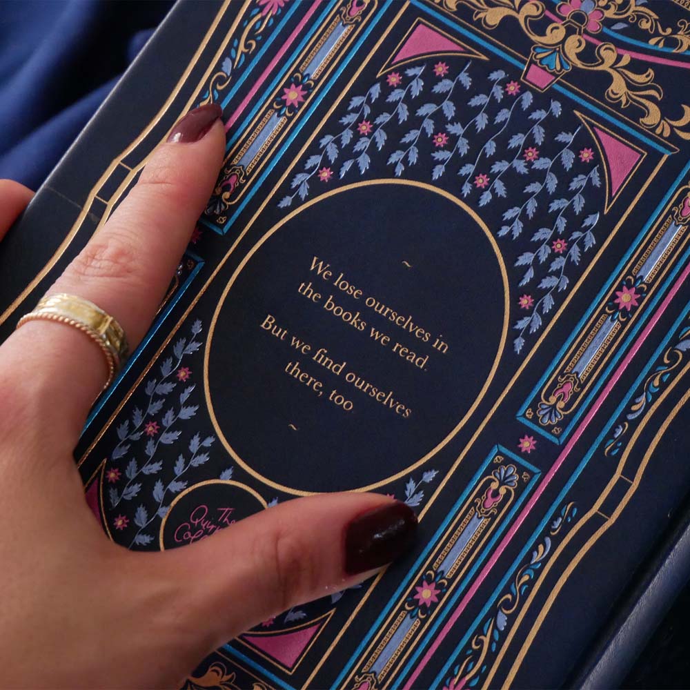 Blue faux leather reading journal with pink flowers, light blue leaves and gold foil filagree, and a pink ribbon bookmark