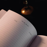 An open Serpents & Swords Reading journal by The Quirky Cup collective shows the 'to be read' reading journal spread. The journal is held open by a hand with intricate red fi.