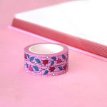 Pink washi tape with pink and red flowers with green leaves on a black vine