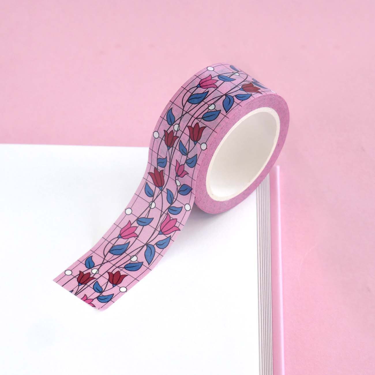 Pink washi tape with pink and red flowers with green leaves on a black vine