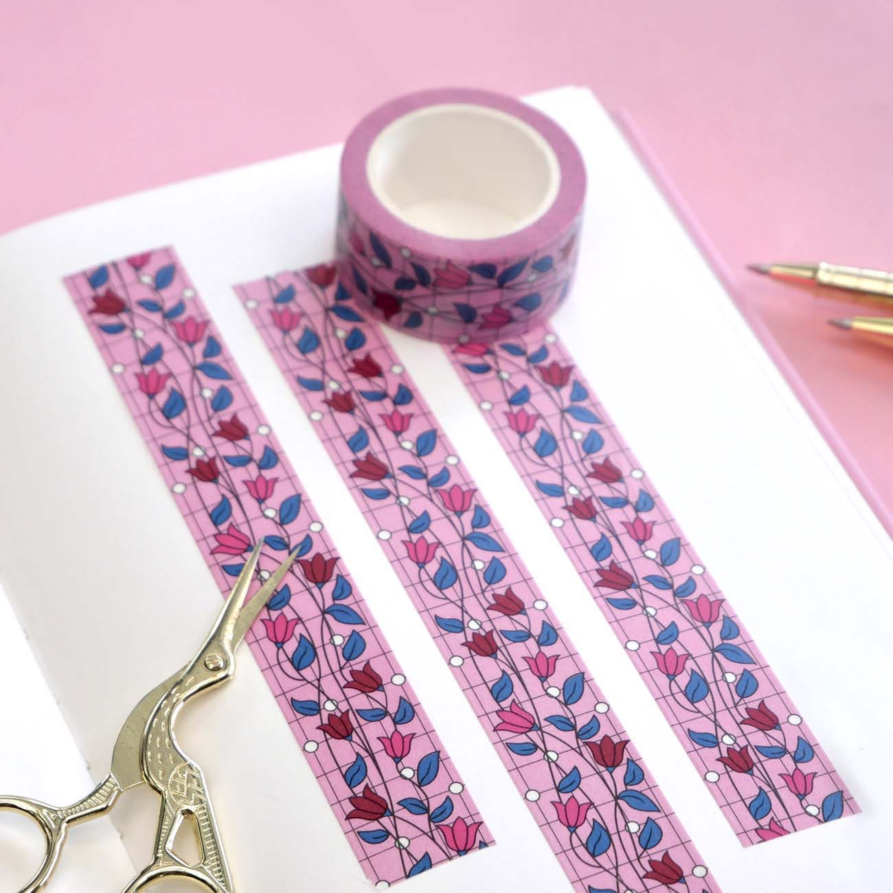 Pink washi tape with pink and red flowers with green leaves on a black vine