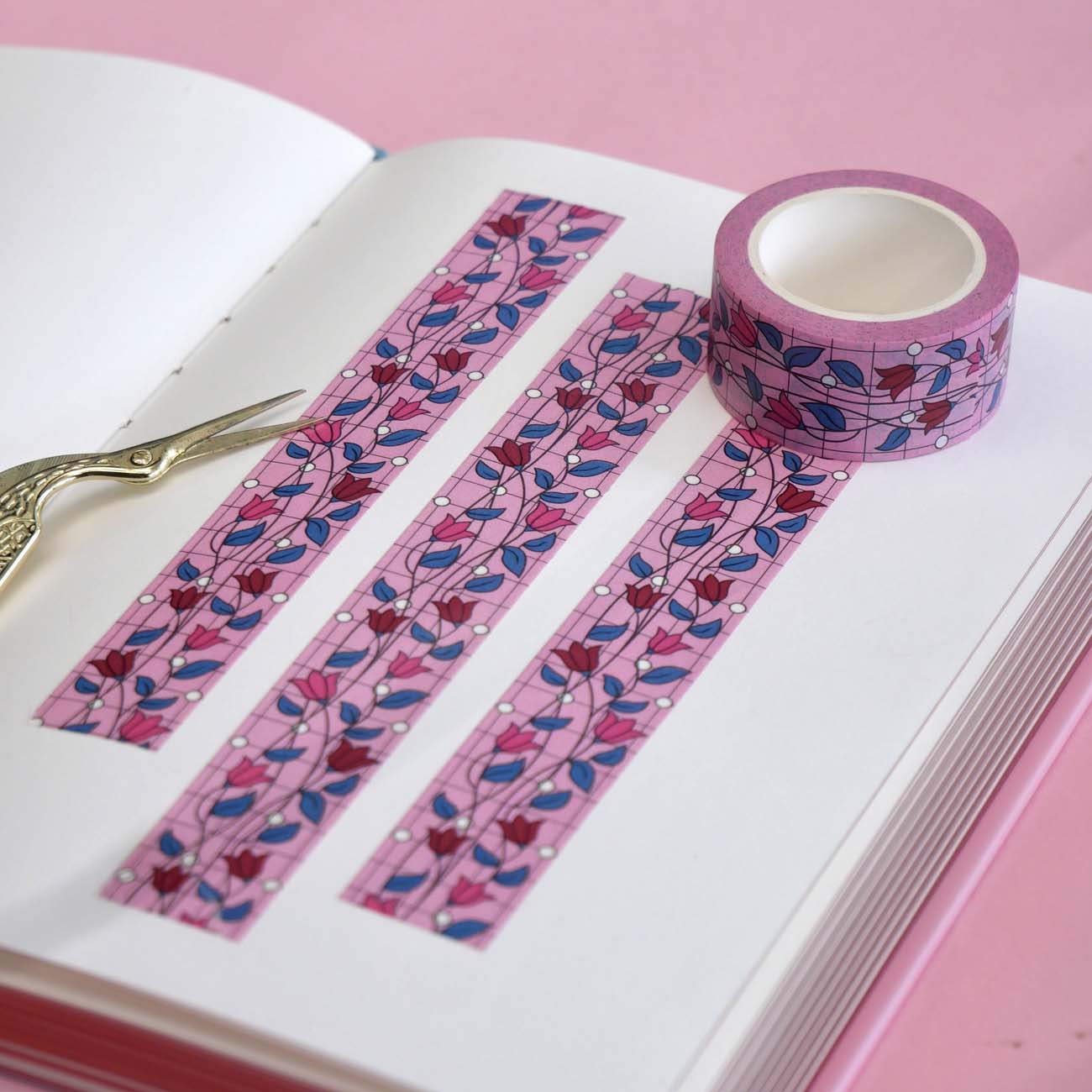 Pink washi tape with pink and red flowers with green leaves on a black vine