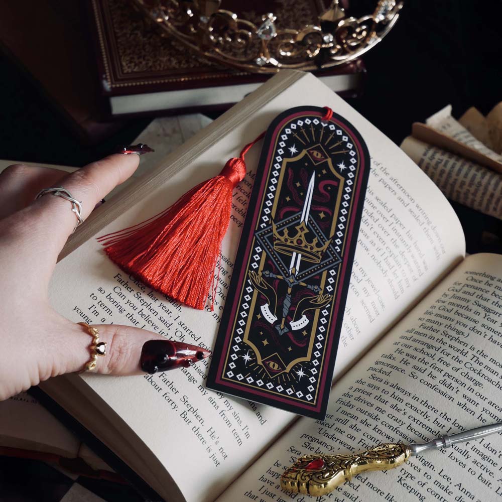 Fantasy bookmark with sword, crown and serpents design, red tassel, gothic black background