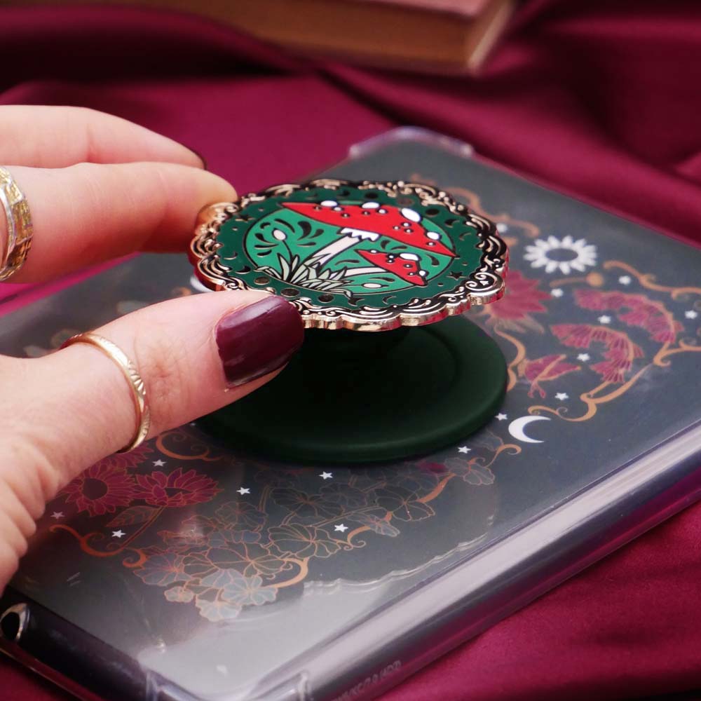 Decorative kindle grip with cottage core design held by a hand against a decorative background