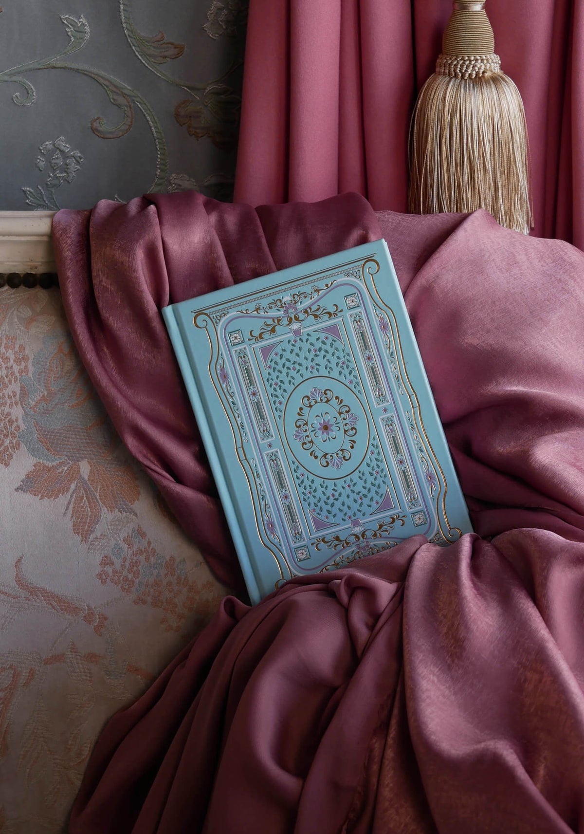 The light blue foiled Antoinette notebook is inspired by a classic french journaling aesthetic. It sits on an ornate french chaise on a pink fabric background to complete the whimsical french journaling aesthetic. 