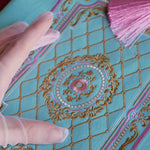 Detail of the intricate embroidery on the front of the Antoinette aqua velvet zippered pouch (aka feminine book sleeve) featuring  gold, pink and cream embroidery detail. The classic literature inspired design is perfect for a feminine french library aesthetic.