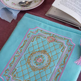 Detail of the intricate embroidery on the front of the Antoinette aqua velvet zippered Book sleeve featuring  gold, pink and cream embroidery detail. The Victorian inspired design is perfect for a classic literature eReader aesthetic.