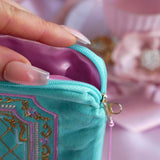Detail of a hand opening the Antoinette aqua velvet zippered pouch (aka feminine eReader sleeve) featuring a pink satin lining and gold, pink and cream embroidery detail.