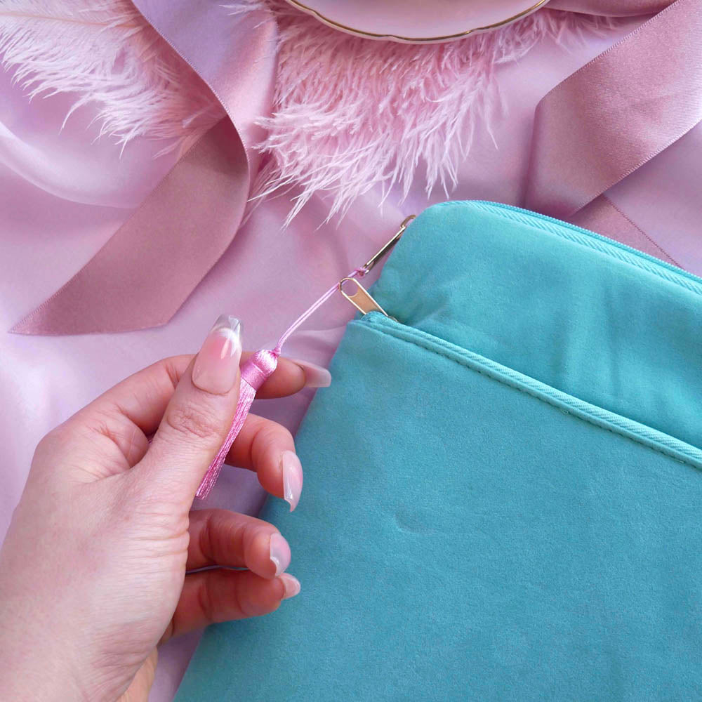 A detail of the aqua Kindle sleeve in Antoinette. The light green velvet Kobo case features pink, cream and gold embroidery with a classic book inspired design. Here the back of the case shows off the rear pocket and pastel pink tassel.