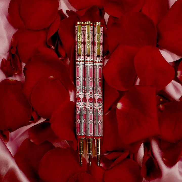 Bite Me Pen- The Quirky Cup Collective - Stained Glass Inspired Pen Design with 'Bite me' engraved on the pen clip. Pen sits on a bed of red rose petals. 