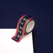 A close up of the Blood Spilled washi tape by The Quirky Cup Collective. The fantasy book inspired washi tape design is pink, blue with gold detailing with a goblet motif.