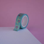The Botanica design of French inspired washi tape as part of the Antoinette collection sits on a light pink background. The bookish washi tape design features flowers on a vibe in shades of pink and foil gold.