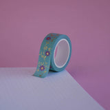The Botanica design of French inspired washi tape as part of the Antoinette collection sits on a light pink background. The bookish washi tape design features flowers on a vibe in shades of pink and foil gold.