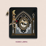Decorated Kobo Libra with a set of ereader accessories that are gold and feature dragons, moons and celestial themes inside a cathedral window