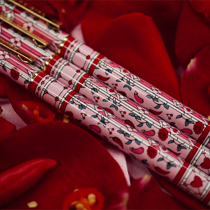 Good Girl - Pink Pen - Black Ink - The Quirky Cup Collective - Stained Glass Inspired Pen Design with 'Bite me' engraved on the pen clip. Pen sits on a bed of red rose petals. 