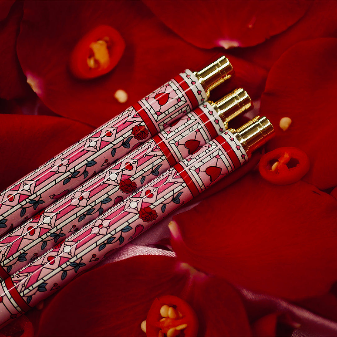 Good Girl - Pink Pen - Black Ink - The Quirky Cup Collective - Stained Glass Inspired Pen Design with 'Bite me' engraved on the pen clip. Pen sits on a bed of red rose petals. 