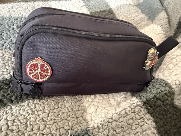 A collection of book inspired enamel pin designs on a pencil case.