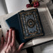 The black literati kindle sticker insert features white and gold foil design in an intricate classical book style.