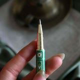 Detail image of the sage green Bibliophile pen by The Quirky Cup Collective. The light green pen features a classic book inspired design in shades of green, white and cream with gold detailing. 