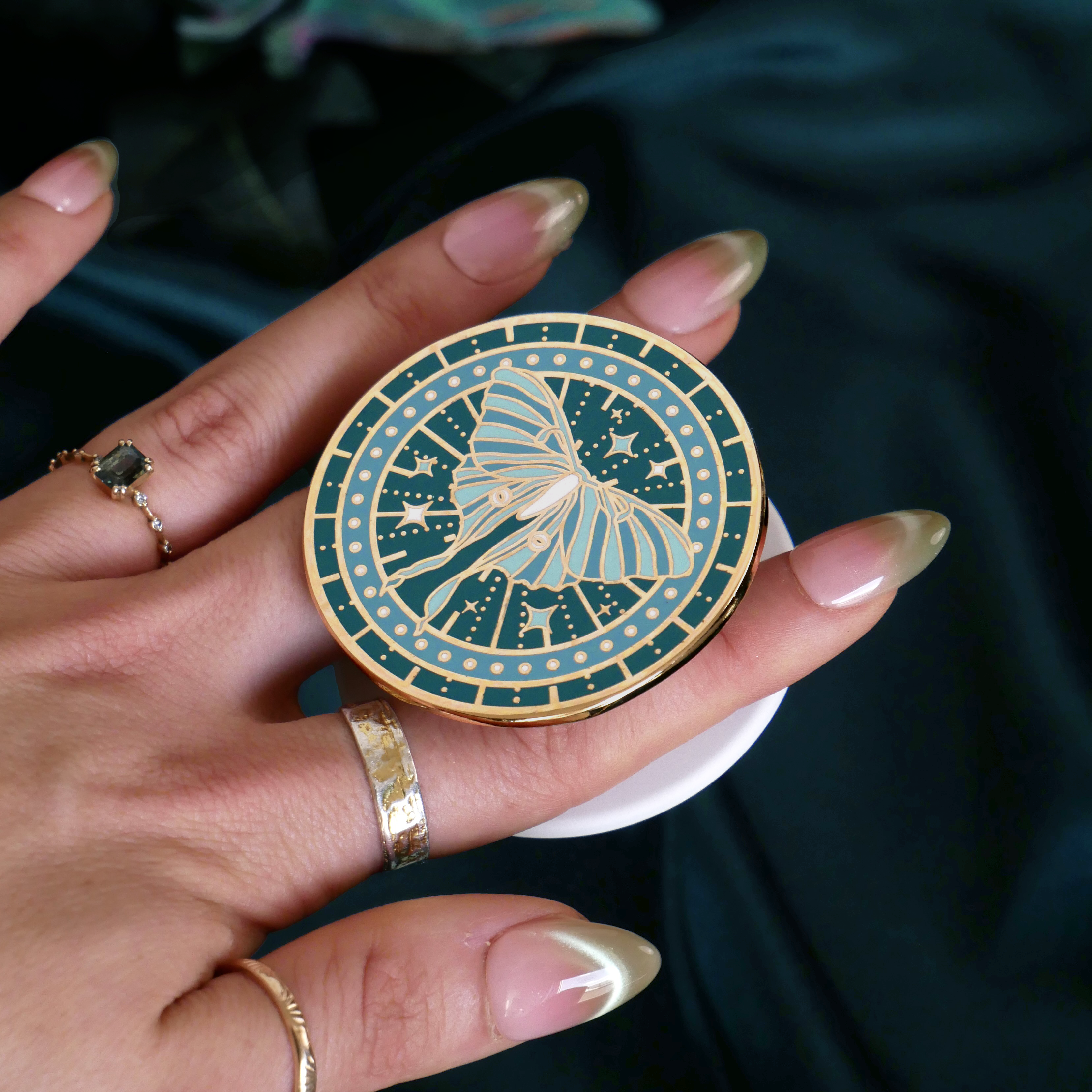 teal kindle grip depicting a luna moth with celestial accents by the quirky cup collective