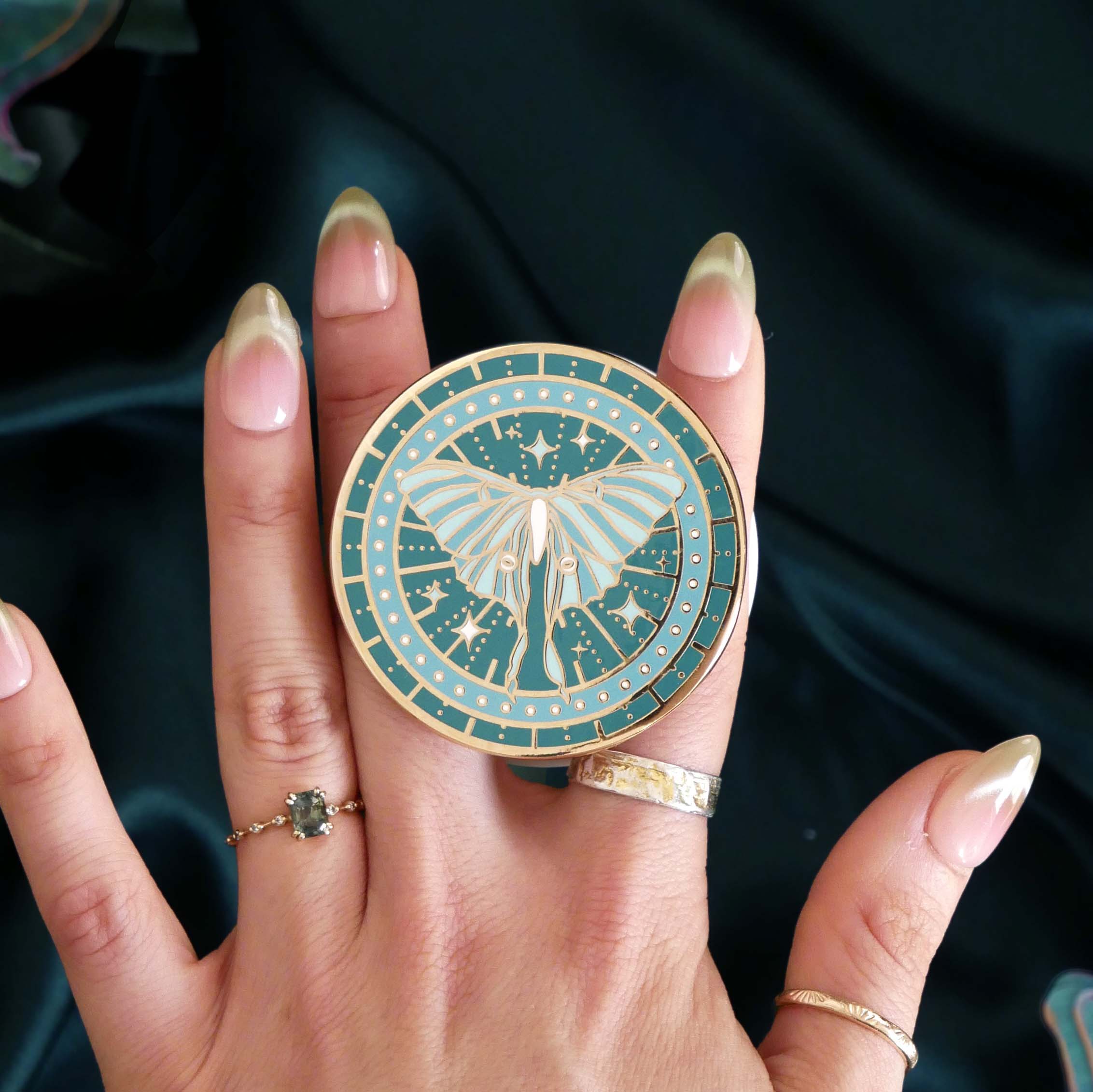 teal phone grip depicting a luna moth with celestial accents by the quirky cup collective