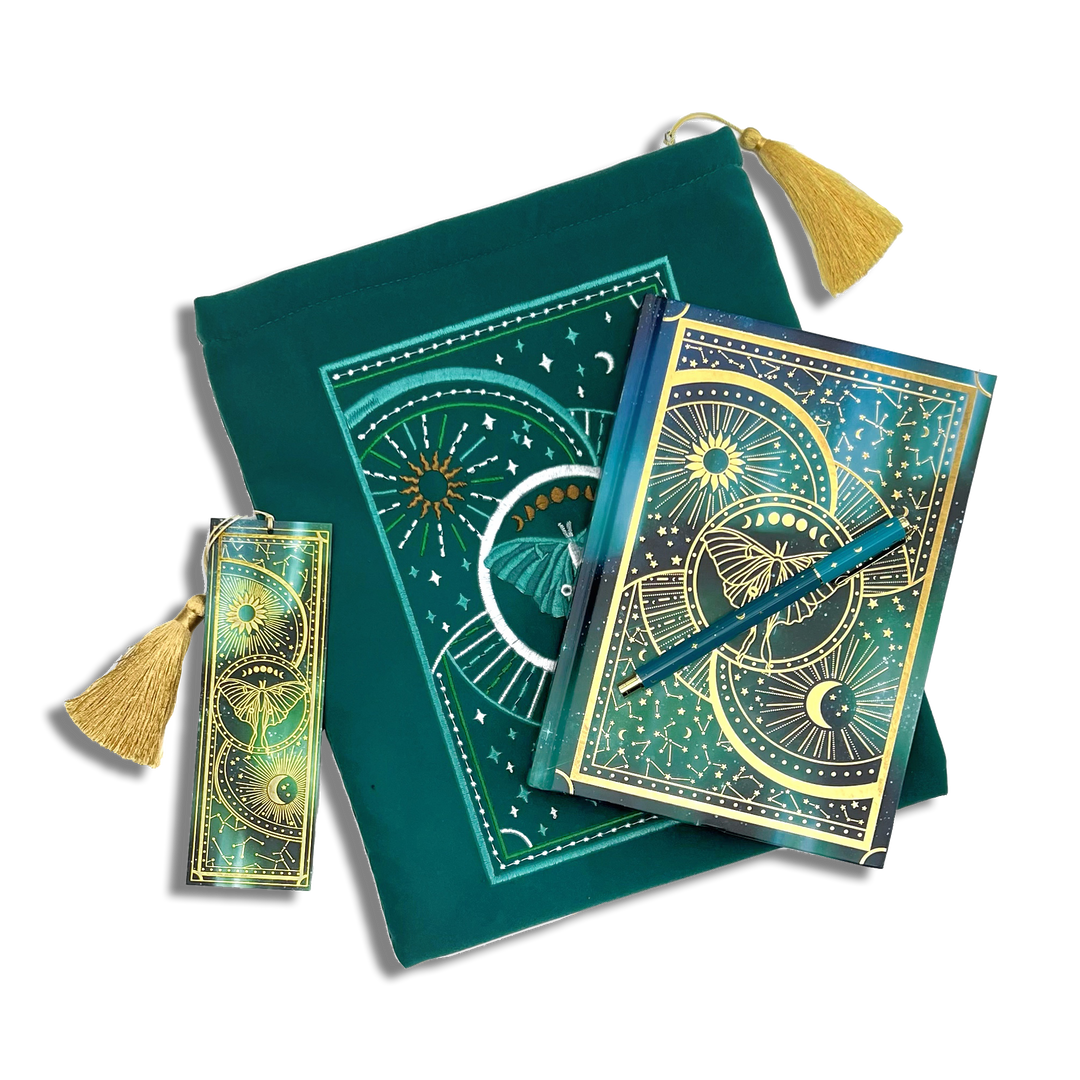 bundle of teal blue stationery items on a plain background. Items are a book sleeve, journal, pen and bookmark. Design features a luna moth with celestial inspired design. 
