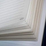 The corner detail of the Oath Breaker journal shows a tiny crown line drawing on the white lined journal pages.