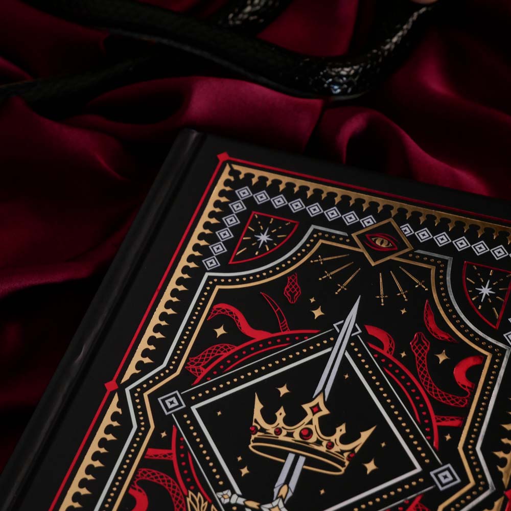 Decorative dark fantasy journal with intricate fantasy themed designs on a red fabric background