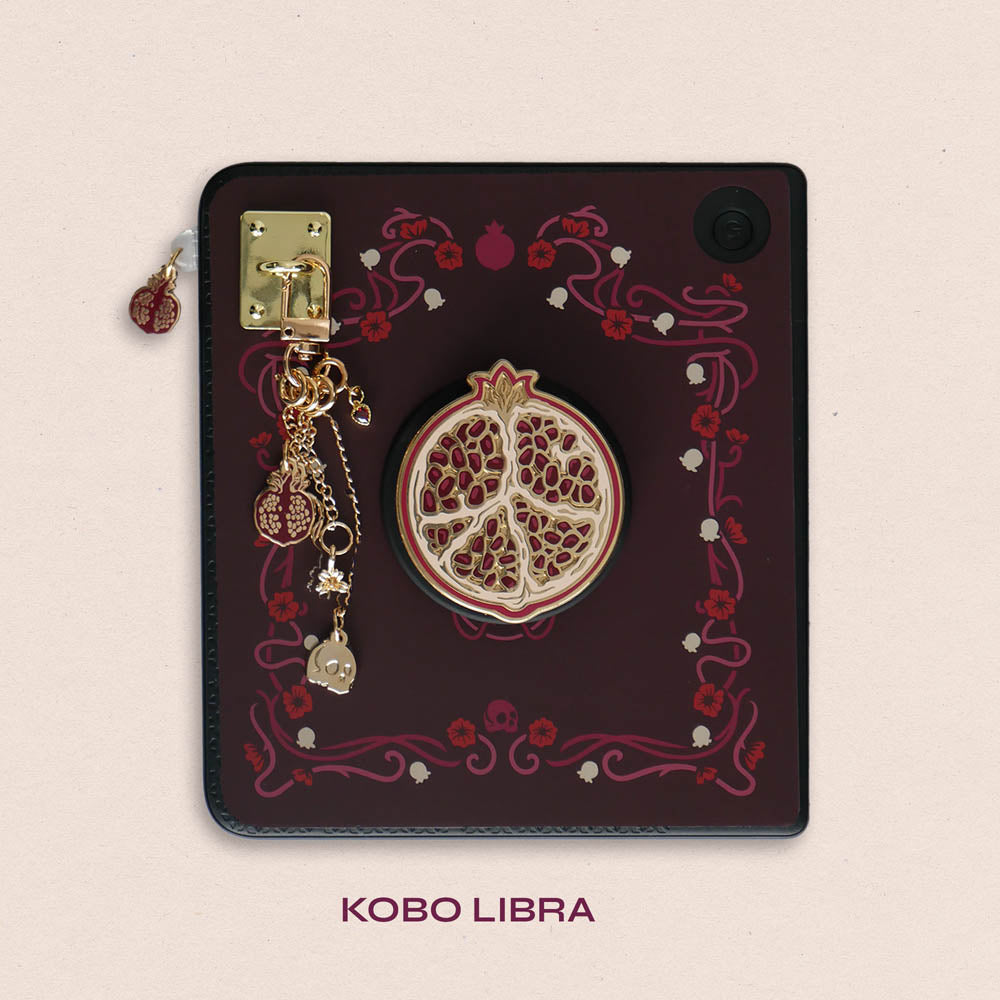 Decorated Kobo Libra with a set of aesthetic ereader accessories that are gold and wine coloured. Theme of products is Persephone and features a pomegranate, a flower, skull, daffodil, poppies and a heart. Inspired by art nouveau