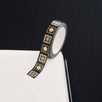 Black washi tape with white and grey flowers in squares outlined in gold foil