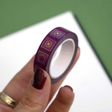 Roll of purple washi tape with green and purple flowers in pink squares outlined in gold foil