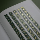 The Sage green variation of the Poetica Literati washi tape. The book inspired washi tape design is shown in five strips on a white journal page sitting on a green background and features geometric flower motifs in shades of dark green, sage green and gold.
