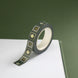 The Sage green variation of the Poetica Literati washi tape. The book inspired washi tape design is shown on the edge of a journal on a green background and features geometric flower motifs in shades of dark green, sage green and gold.