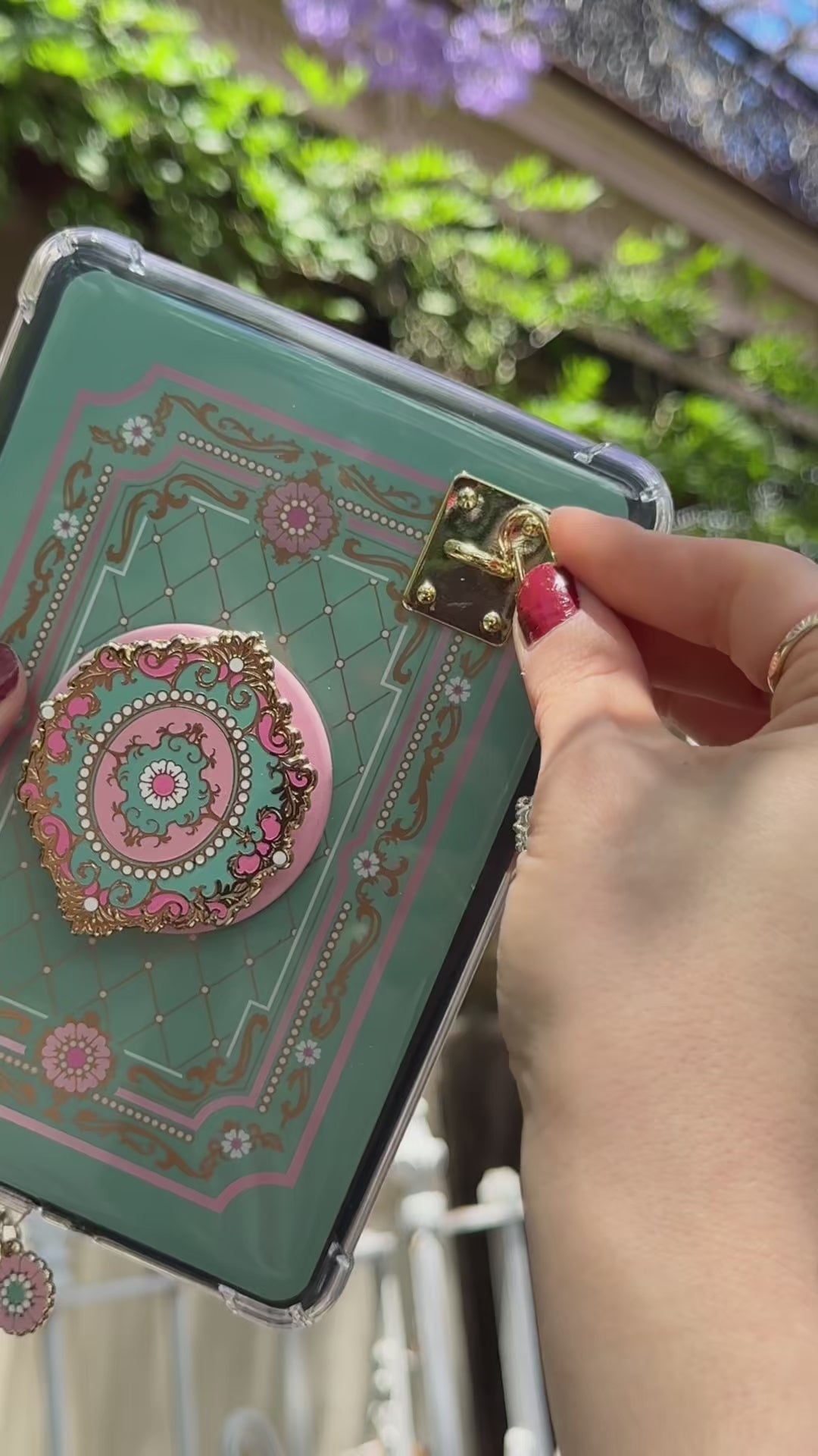 A video showing the Antionette Rider e-reader bundle (aka a kindle decor set) by The Quirky Cup Collective in use. The embroidered kindle case, kindle insert sticker, charmlet (attached with a charm anchor) and kindle pop socket (aka a clingie) feature a mint green with pink and gold floral detailing